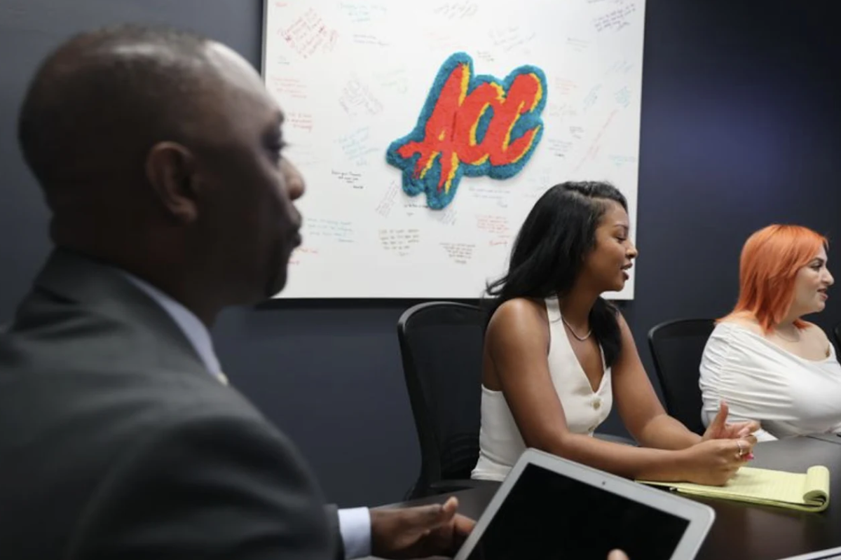 AOC Outreach Services team members in a meeting room in front of a whiteboard featuring the AOC logo and client notes